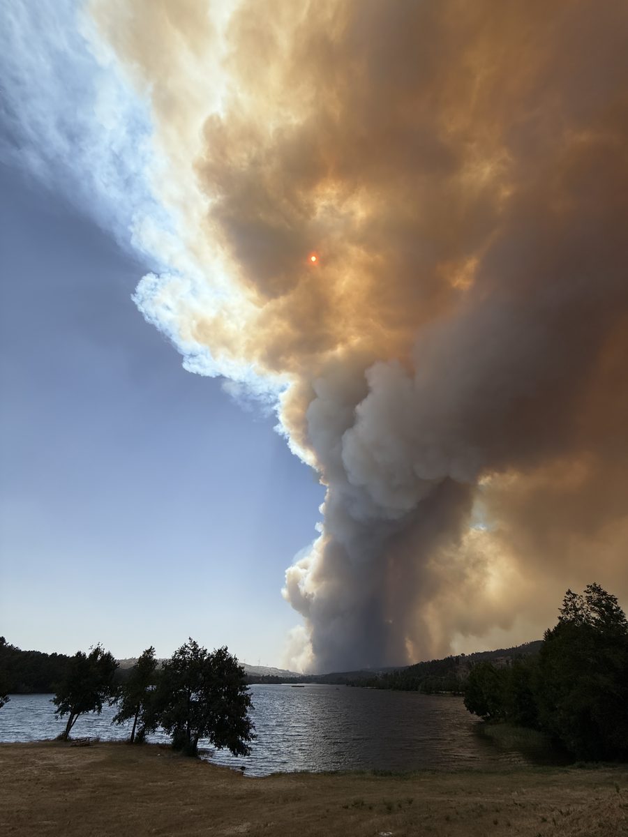 Rauchsäule des Waldbrands von Trancoso über einem Stausee im August 2025